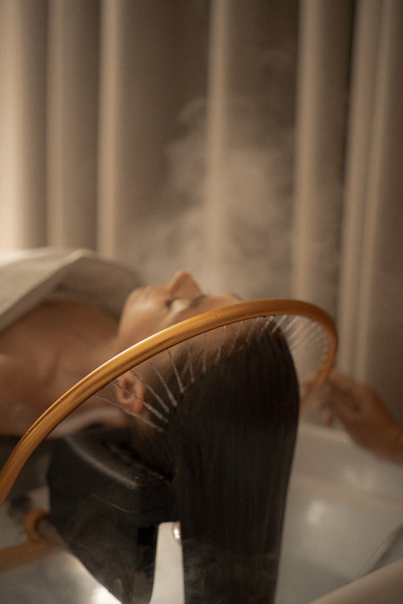 Person using a handheld showerhead in a steamy bathroom