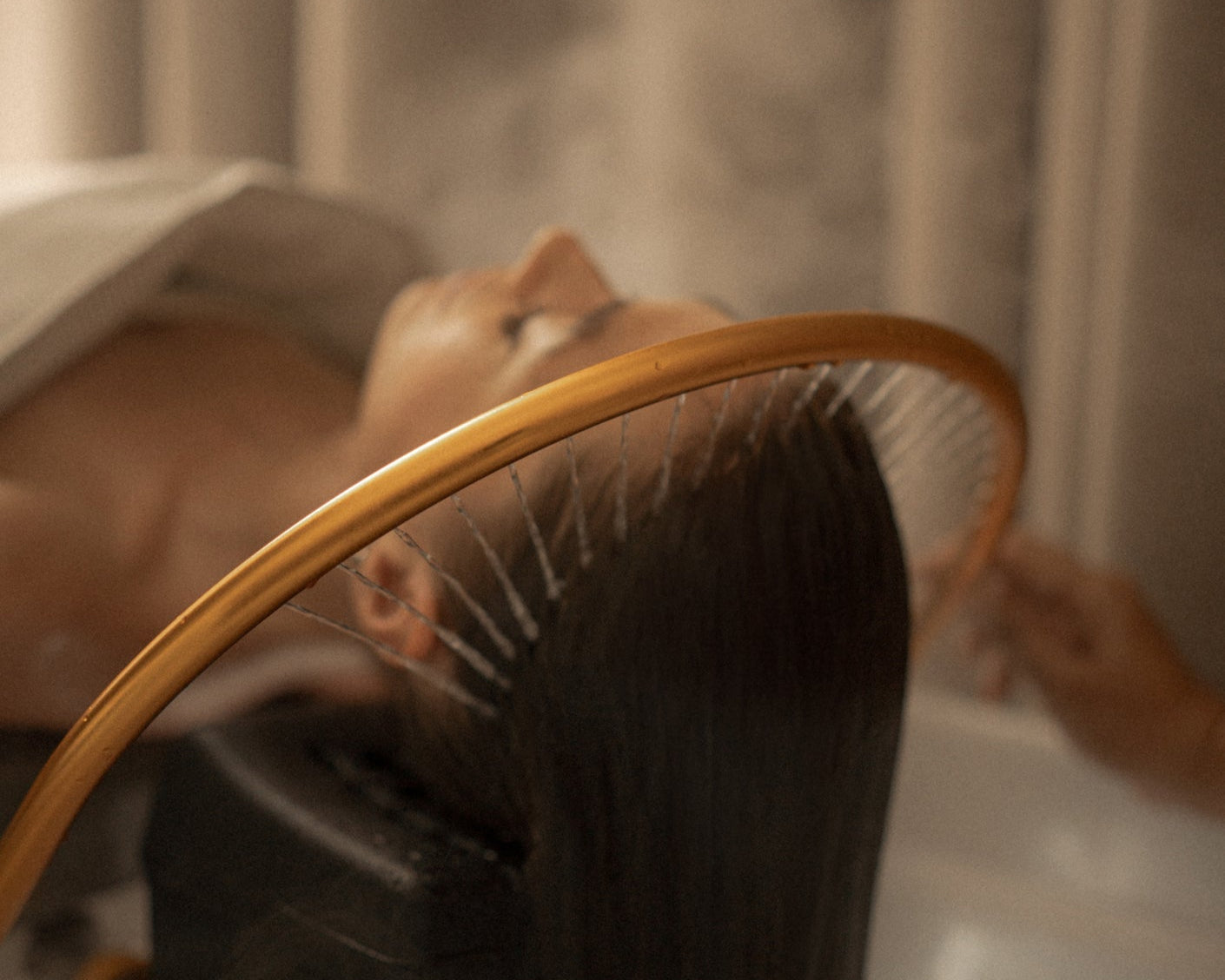 Person using a handheld showerhead in a steamy bathroom